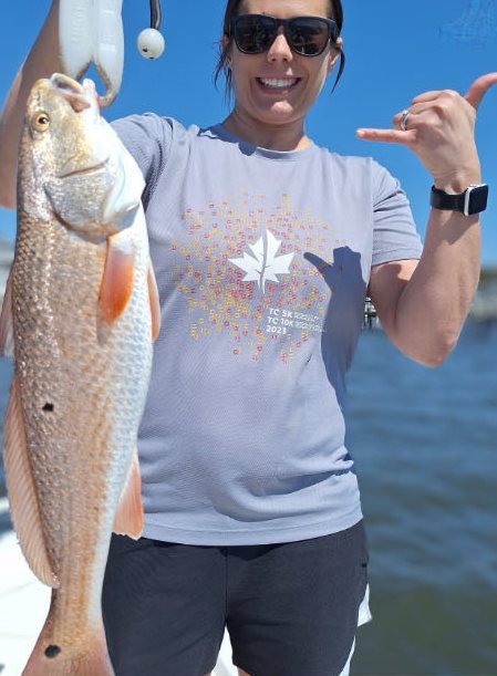 Angler with a redfish giving a shaka sign